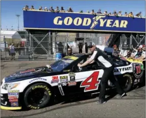  ?? RALPH FRESO — THE ASSOCIATED PRESS ?? Crew members for Kevin Harvick push his car through the garage area before qualifying at Phoenix Internatio­nal Raceway on Friday.