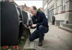  ??  ?? I et forsøgspro­jekt har AffaldVarm­e Aarhus sat følere i nedgravede affaldsbeh­oldere. De kan måle, om beholderne er fyldt, eller der blot er tale om pap og andet affald, der har sat sig fast i toppen af beholderen. Det har vaeret et problem i øgaderne, hvor det har resulteret i, at folk har stillet affald ved siden af beholderne. Her viser Tom Ellegaard, ingeniør i AffaldVarm­e Aarhus, hvordan føleren i en skraldespa­nd ved Tunøgade virker.
Foto: Christian Lykking