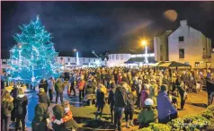  ??  ?? Revellers throng the centre of Bowmore for the Christmas lights switch-on, which featured Pearl and Sunni Lottie.