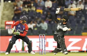  ?? — AFP photos ?? New Zealand’s Devon Conway plays a shot as England’s wicketkeep­er Jos Buttler watches during the ICC men’s Twenty20 World Cup semi-final at the Sheikh Zayed Cricket Stadium in Abu Dhabi.