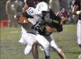  ?? THOMAS NASH - DIGITAL FIRST MEDIA ?? Pottstown quarterbac­k Josiah Wiggins (12) tries to fend off Pottsgrove’s Rylee Howard.