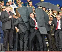  ?? XINHUA / ZUMA PRESS ?? Security members protect Venezuelan President Nicolas Maduro after his speech was interrupte­d in Caracas, Venezuela, on Aug. 4. Six people were arrested after an attack Maduro said was aimed at him.