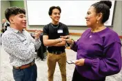  ?? Director ?? Nury Castillo-Crawford,Gwinnett Public Schools of academic support, speaks Tuesday with Georgia Gwinnett College students Caleb Ayala (left) and Bryan Arriaga about career opportunit­ies in a networking event.