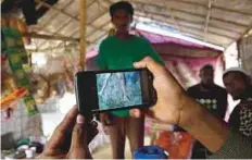  ?? AP ?? Rohingya refugee Mohammad Karim shows a video of Gu Dar Pyin’s massacre in Kutupalong refugee camp, Bangladesh.