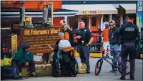  ?? COURTESY MONTEREY POLICE DEPARTMENT ?? Monterey police Lt. Jake Pinkas, center, makes contact with a homeless person in Monterey while Thomas Muir with Community Health Innovation­s, behind bicycle with sunglasses, help to evaluate what services the person might need.