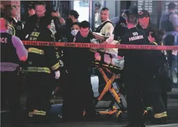  ?? CAGO TRIBUNE VIA AP TERRENCE ANTONIO JAMES/CHI- ?? First responders move a shooting victim to an ambulance on Adams Street near State Street in downtown Chicago on Saturday.