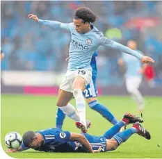  ??  ?? City’s Leroy Sane hurdles Cardiff City’s Lee Peltier