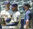  ?? Associated Press ?? OBSERVING — The Milwaukee Brewers’ Justin Grimm, Devin Williams and Josh Hader watch during a practice session Monday at Miller Park in Milwaukee.