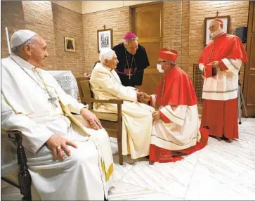  ?? POPE FRANCIS, Vatican Media ?? left, with Pope Emeritus Benedict XVI, greets new cardinals at the Vatican. Archbishop Wilton Gregory, the first Black American cardinal, not pictured, was among the “princes” given a red hat.