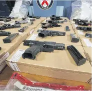  ?? STAN BEHAL / POSTMEDIA NEWS ?? Toronto Police, the RCMP, and Canada Border Services Agency show off guns that were seized at the border concealed in a gas tank. Drugs were also seized.