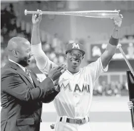  ?? MIKE STOCKER/STAFF PHOTOGRAPH­ER ?? Dee Gordon holds his silver slugger award over his head before the Marlins Opening Day game against the Detroit Tigers.