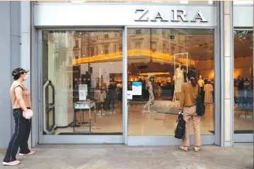  ?? (Hannah McKay/Reuters) ?? A WOMAN looks through a window of a ZARA store in London yesterday. The coronaviru­s ‘reset the economy back to a recession, and now you’re in a brand new economic cycle. That typically favors value names,’ said Ernesto Ramos, head of equities at BMO Global Asset Management.