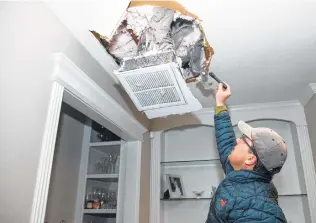  ?? Yi-Chin Lee / Staff photograph­er ?? The sheetrock underneath a burst pipe in Nick Conway’s attic comes down due to a leak. Conway called his plumber but was told he was the 10th person in line, so he tried to fix it himself.