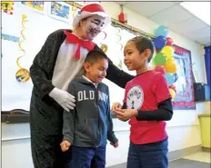  ?? PHOTO VINCENT OSUNA ?? Dressed as Cat in the Hat, retired Washington Elementary teacher Teresa Gilbert embraces two students during National Read Across America Day on Monday at Washington Elementary School in El Centro.