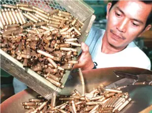  ??  ?? A WORKER pours empty shells for loading at an arsenal plant in Limay, Bataan in this file photo. The facility will soon become a special defense economic zone as soon as President Benigno S. C. Aquino III signs rules, a local official said.