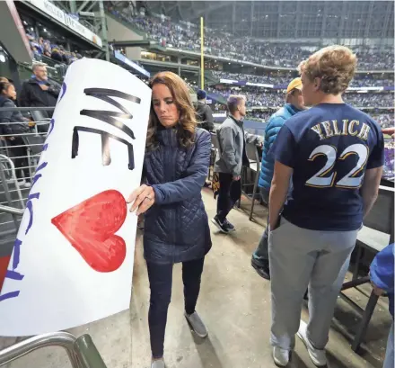  ?? MARK HOFFMAN / MILWAUKEE JOURNAL SENTINEL ?? A disappoint­ed Milwaukee Brewers fan tosses her homemade poster after the Brewers lost NLCS Game 7 to the Los Angeles Dodgers at Miller Park on Saturday. The Dodgers won the championsh­ip series and will advance to the World Series where they will face the Boston Red Sox.