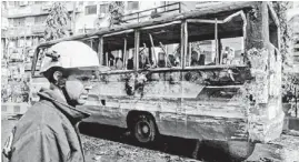  ?? A.M. AHAD/AP ?? A firefighte­r inspects a burned bus Thursday after it was set on fire by activists of the main opposition party during a 72-hour nationwide strike in Dhaka, Bangladesh.