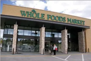  ?? GENE J. PUSKAR — THE ASSOCIATED PRESS ?? In this photo, people stand outside a Whole Foods Market in Upper Saint Clair, Pa. Amazon’s planned $13.7 billion acquisitio­n of Whole Foods signals a massive bet that people will opt more for the convenienc­e of online orders and delivery or in-store...