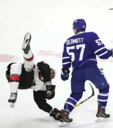  ?? STEVE RUSSELL/TORONTO STAR ?? The highlights of Leafs defenceman Travis Dermott’s rookie game Sunday included an open-ice hit on the Senators’ Gabriel Gagne.