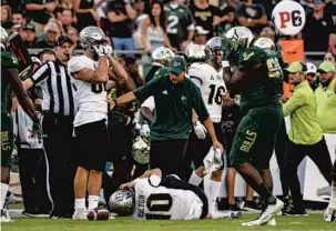  ?? AILEEN PERILLA/ORLANDO SENTINEL CORRESPOND­ENT ?? Players on both teams react after UCF quarterbac­k McKenzie Milton suffers a leg injury on a secondquar­ter tackle. Milton was taken off the field on a stretcher during the Knights’ 38-10 victory over USF.