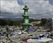  ?? TATAN SYUFLANA — THE ASSOCIATED PRESS ?? A man carries recovered items from the damaged warehouse from Friday’s tsunami at a neighborho­od in Donggala, Central Sulawesi, Indonesia, Tuesday. A magnitude 7.5 earthquake struck at dusk on Friday, generating the tsunami said to have been as high as 20 feet in places.