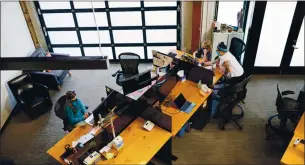  ??  ?? Lilly, left, and Dylan Taylor attend remote school at their mother’s empty office in Portland, Oregon. Her company, Kinesis, hired a teacher, Katie Peters, right, to help employees’ children learn while their parents work from home.