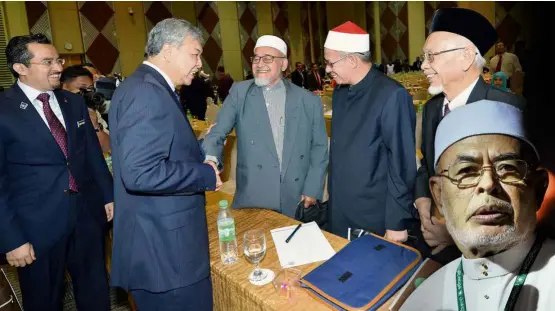  ??  ?? Jovial meeting:
Dr Mahfodz (centre), the man most likely to be the next Mursyidul Am of PAS, getting a warm greeting from Deputy Prime Minister Datuk Seri Dr Ahmad Zahid Hamidi at the Islamic Consultati­ve Council meeting. With them are (from left)...