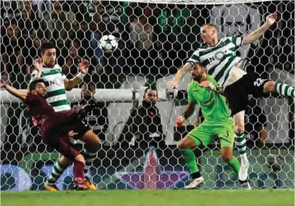  ??  ?? LISBON: Barcelona’s Uruguayan forward Luis Suarez (L) kicks the ball during the UEFA Champions League Group D football match Sporting CP vs FC Barcelona at the Jose Alvalade stadium in Lisbon yesterday. — AFP