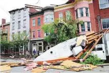  ?? AFP ?? Men stand near buildings damaged by a storm in Newburgh, New York, yesterday, after powerful storms pounded the Northeast on Tuesday.