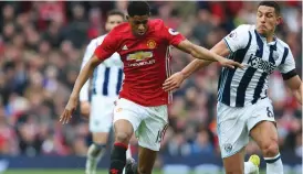  ??  ?? Marcus Rashford and Jake Livermore compete for possession