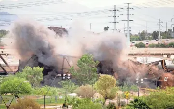  ??  ?? A section of the damaged railroad bridge over Tempe Town Lake is detonated Sunday.