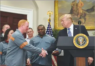  ?? AP PHOTO ?? President Donald Trump reaches out to shake the hand of Dusty Stevens, a superinten­dent at Century Aluminum Potline, during an event in the Roosevelt Room of the White House in Washington, Thursday.