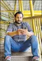  ?? AFP PHOTO ?? A man browses the internet on his phone on a footbridge in Srinagar.