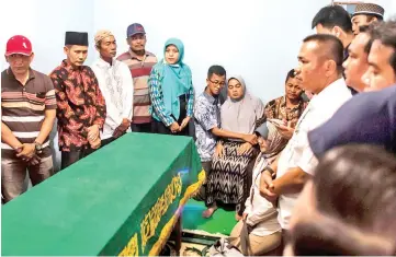  ?? — AFP photo ?? Family members gather with the parents (back centre and right) of Dewi next to the coffin (left) before her funeral in Sidiarjo in East Java province.