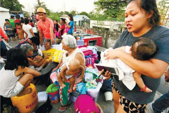  ?? (SUN.STAR FOTO/ALEX BADAYOS) ?? FAMILY MATTERS. Leo Ramos, 66, receives treatment (background, left) for a scratch he got while being carried out of a burning house in Carreta, Cebu City. His wife Maria, daughter Dannilyn and 3-week-old grandchild Ricajane also survived.