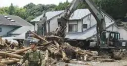  ?? —AFP ?? ASAKURA: Defense forces soldiers remove debris in a flooded area in Asakura, Fukuoka prefecture.
