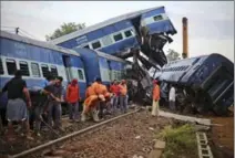  ?? ALTAF QADRI, THE ASSOCIATED PRESS ?? Workers repair the track near the upturned coaches of the Kalinga-Utkal Express after a fatal accident near Khatauli, Sunday.