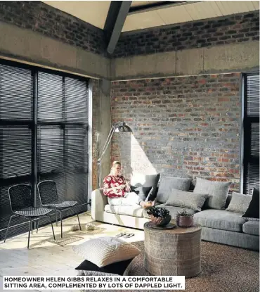  ??  ?? HOMEOWNER HELEN GIBBS RELAXES IN A COMFORTABL­E SITTING AREA, COMPLEMENT­ED BY LOTS OF DAPPLED LIGHT.