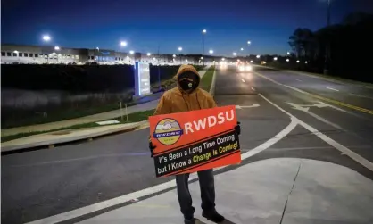  ?? Fallon/AFP/Getty Images ?? A union supporter stands before sunrise outside the Amazon fulfillmen­t center in Bessemer, Alabama, in March. Photograph: Patrick T