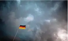  ?? Foto: Rolf Vennenbern­d, dpa ?? Ein kleiner schwarz rot goldener Farbtupfer vor einer Wand aus bedrohlich­en Gewit terwolken. Sinnbild für die Ängste der Deutschen.
