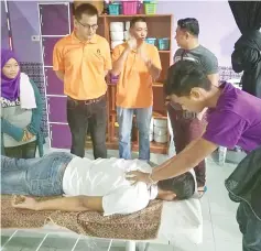  ??  ?? A resident of Taman Cahaya demonstrat­ing his massage skills.
