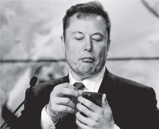  ?? JOE SKIPPER ■ REUTERS ?? Elon Musk checks his phone at an event in Cape Canaveral, Florida, in January 2020.