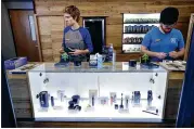  ?? STEVEN SENNE/AP ?? Associates Savannah Stuitje and Josh Hirst stand at a counter featuring vape dispensers at a medical marijuana dispensary in Northampto­n, Mass.