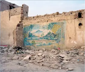  ??  ?? May 2016. A mural on the wall of a ruined building in the ancient Islamic city of Kashgar, once an important stop on the Silk Road. The Chinese authoritie­s are building a new version of the city. In the process, they have knocked down about 85 per cent of the original buildings, including mosques, markets and centuries-old houses.