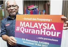  ??  ?? Hussamuddi­n holding a promotiona­l poster for Malaysia # QuranHour in Shah Alam. Spreading the word: