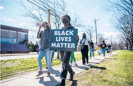  ?? KASSI JACKSON/HARTFORD COURANT ?? Jill Williams, 14, holds a Black Lives Matter sign as she marches with Erin Melocowsky, a recent Glastonbur­y High School graduate, as they lead a BLM860 Youth Coalition rally in opposition to what they said is a Glastonbur­y public school system culture of racism, sexism, classism and discrimina­tion. They marched from the Hubbard Green to Glastonbur­y High School.