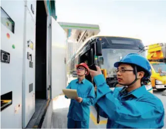  ??  ?? Workers from a power supply company in Yinzhou District of Ningbo check a supercapac­itor charging station for electric buses. by Wang Xiaochuan/xinhua