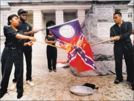  ?? W.A. Bridges Jr. ?? The Associated Press In this June 1992 photo, from left, Ina Solomon, Jeffery Harris, Stacey Abrams and Lawrence Jeffries burn a Georgia state flag during a demonstrat­ion in Atlanta.