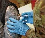  ?? BILL LACKEY / STAFF ?? Members of the National Guard gave senior residents at Shawnee Place Apartments a COVID vaccine shot Thursday during a clinic set up at the apartments.