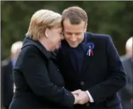  ?? AP PHOTO/MICHEL EULER ?? French President Emmanuel Macron, right, holds the hands of German Chancellor Angela Merkel during a ceremony Saturday in Compiegne, France. The leaders of France and Germany have held an intimate commemorat­ion at the site north of Paris where the vanquished Germans and victorious but exhausted Allies put an end to World War 1.